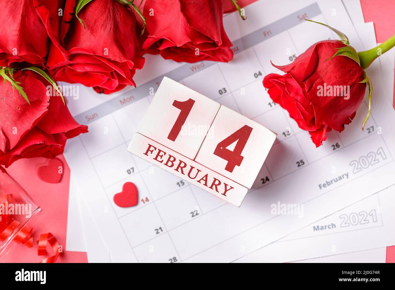 Valentinstag. Rote Feuerstellen und Rosen auf Kalenderseite. 14. Februar des Valentinstag. Rosa Hintergrund. Stockfoto