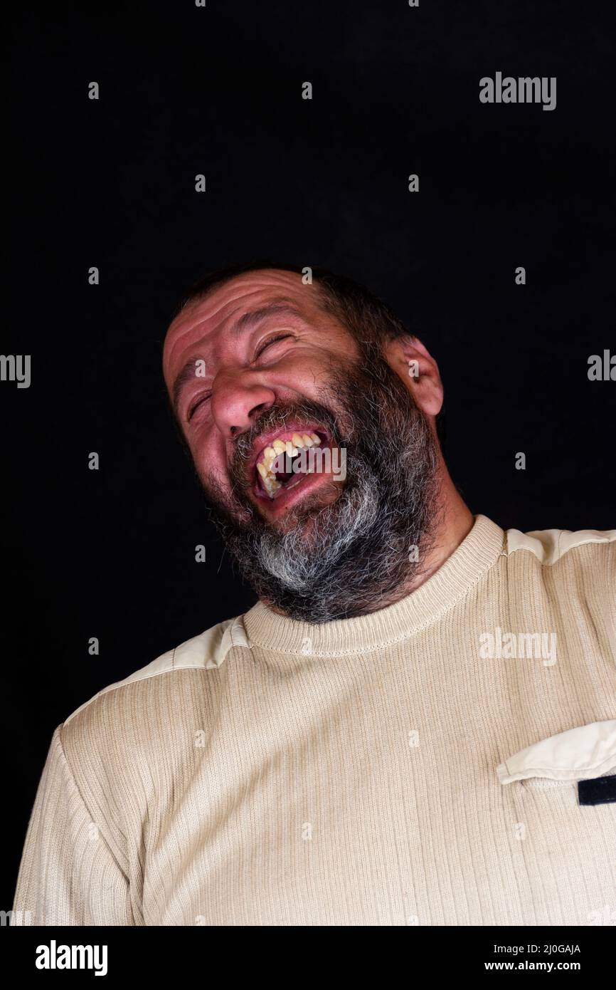 Porträt eines lachenden grauen bärtigen Armeniers auf dunkelgrauem Hintergrund Stockfoto