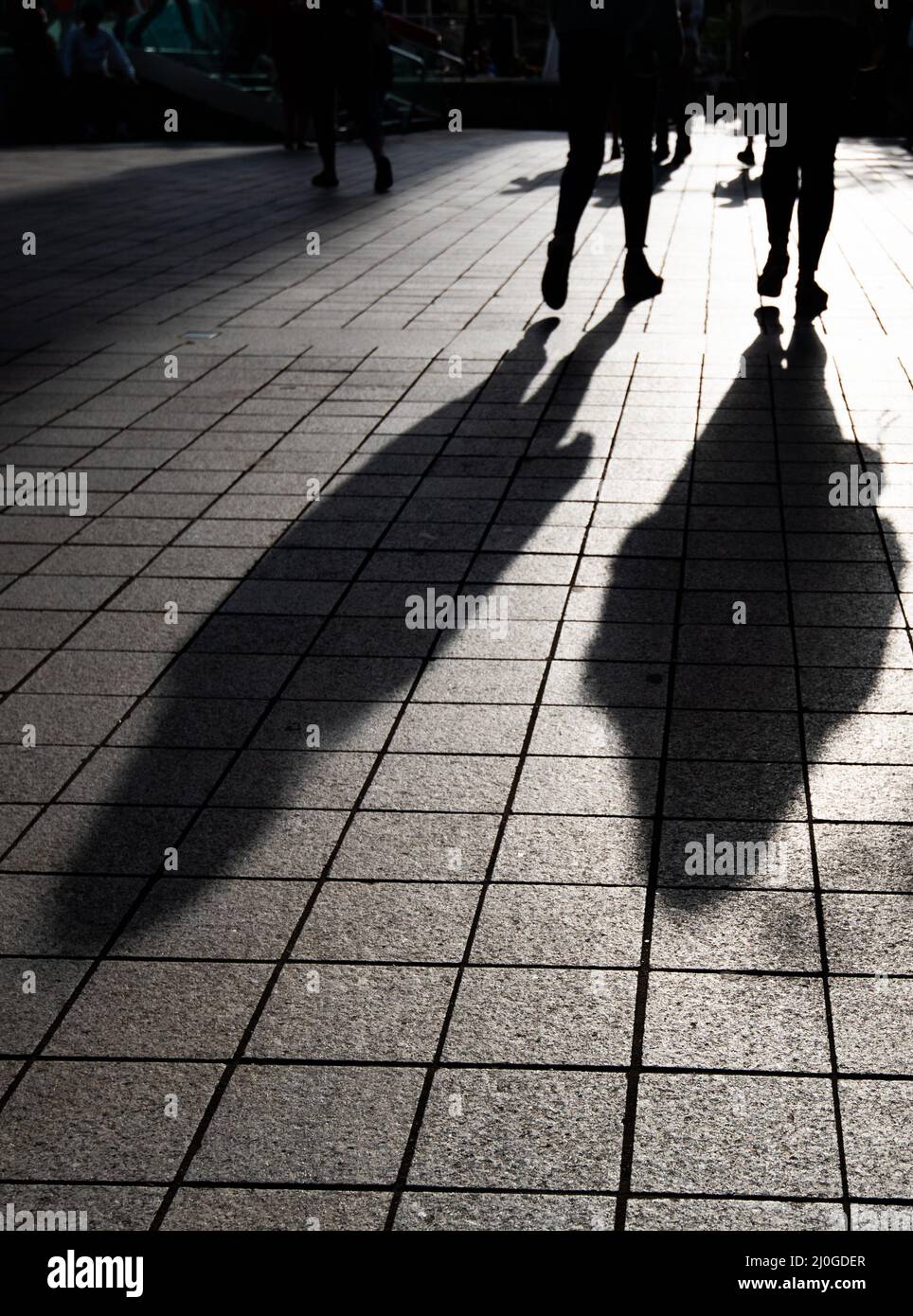 Silhouette von unerkannten Menschen, die auf der Straße spazieren. Stockfoto