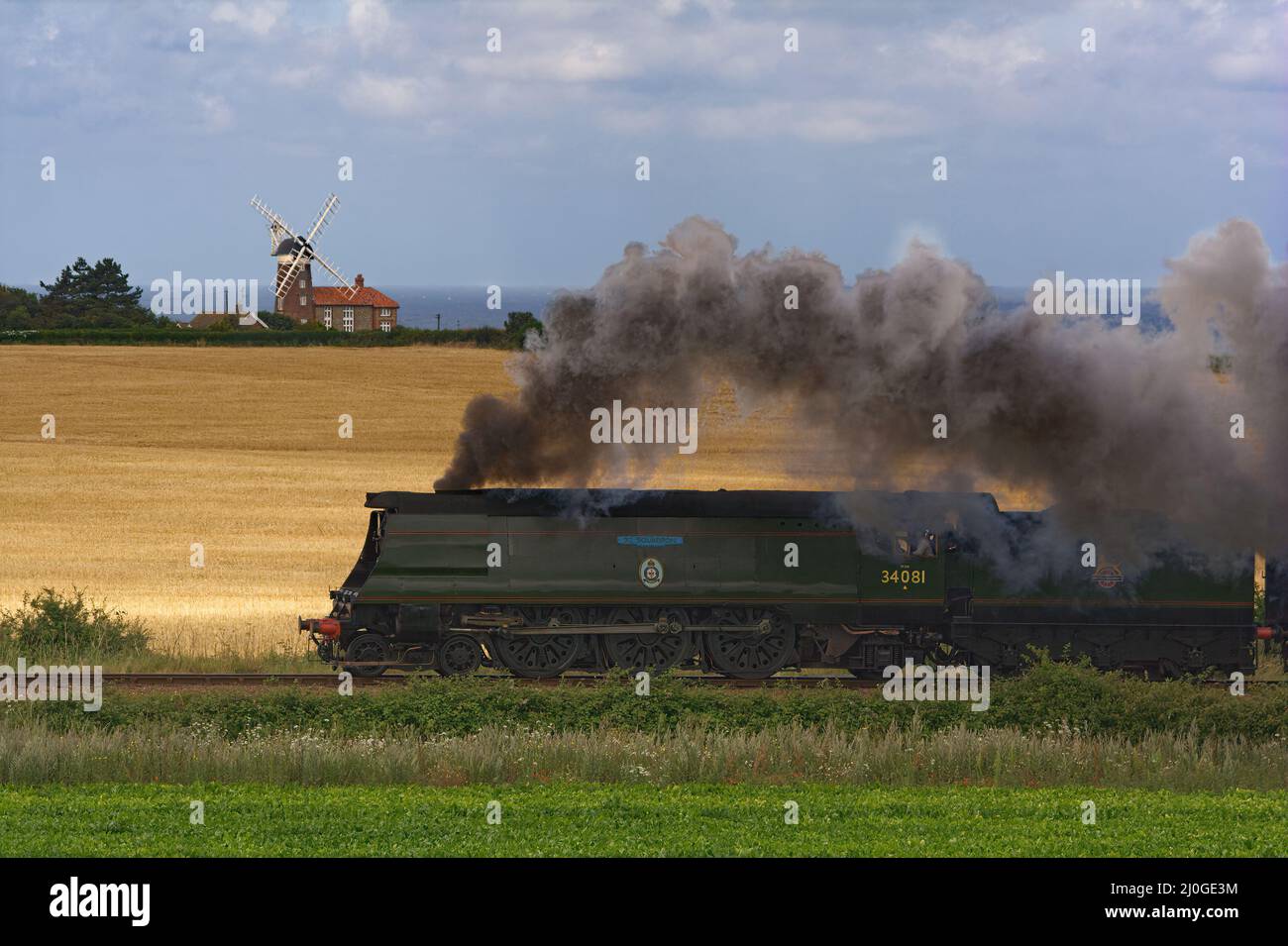 Dampflokomotive 34081 92 Squadron, vorbei an Weybourne Windmühle, North Norfolk Railway. Stockfoto