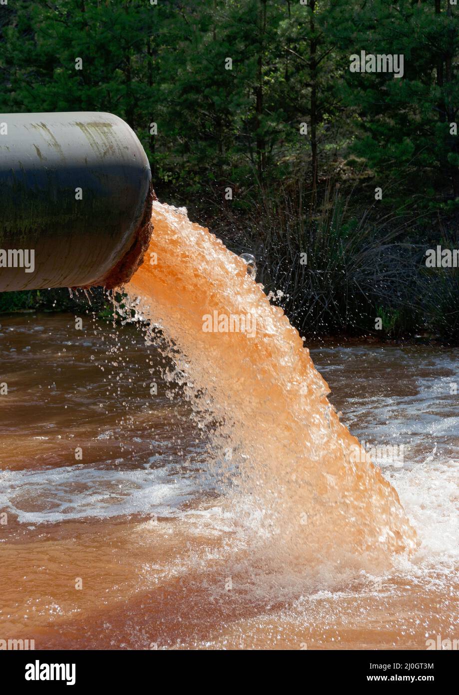 Das Abwasser wird im Hochformat in den Fluss geleitet Stockfoto