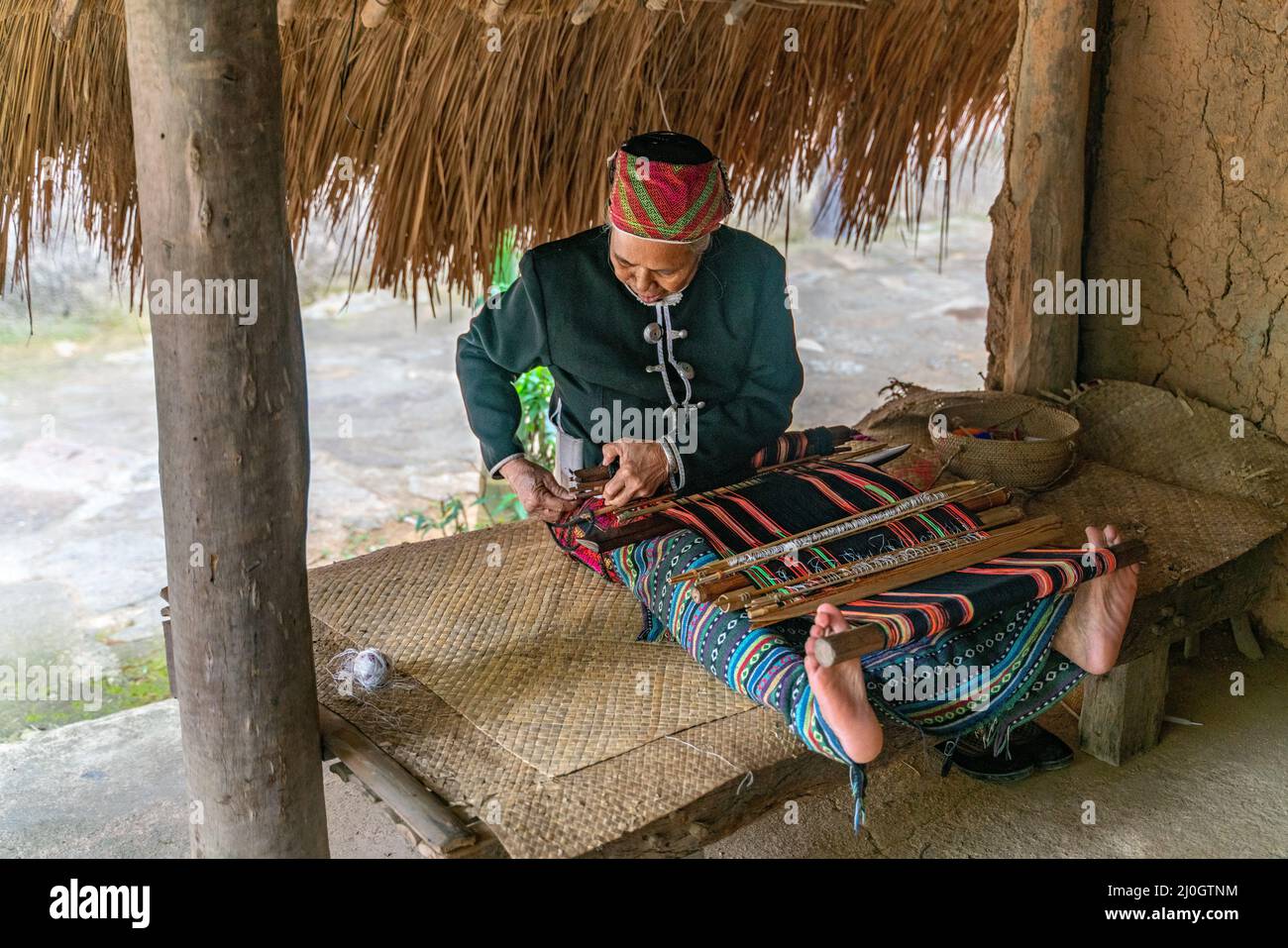 Alte Frau näht in traditionellem Stammeskleid Stockfoto