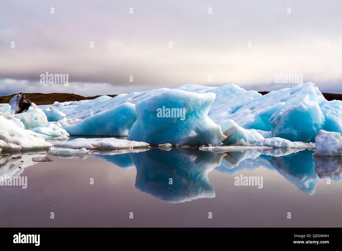 Die Eisberge spiegelten sich im glatten Wasser wider Stockfoto