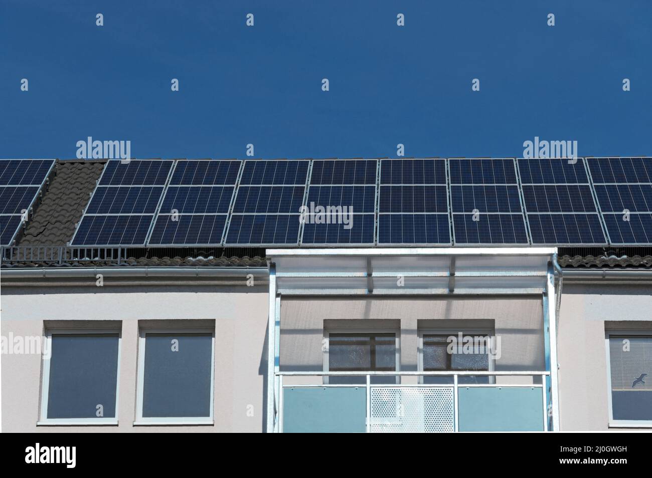 Solarmodule auf dem Dach eines Mehrfamilienhauses Stockfoto