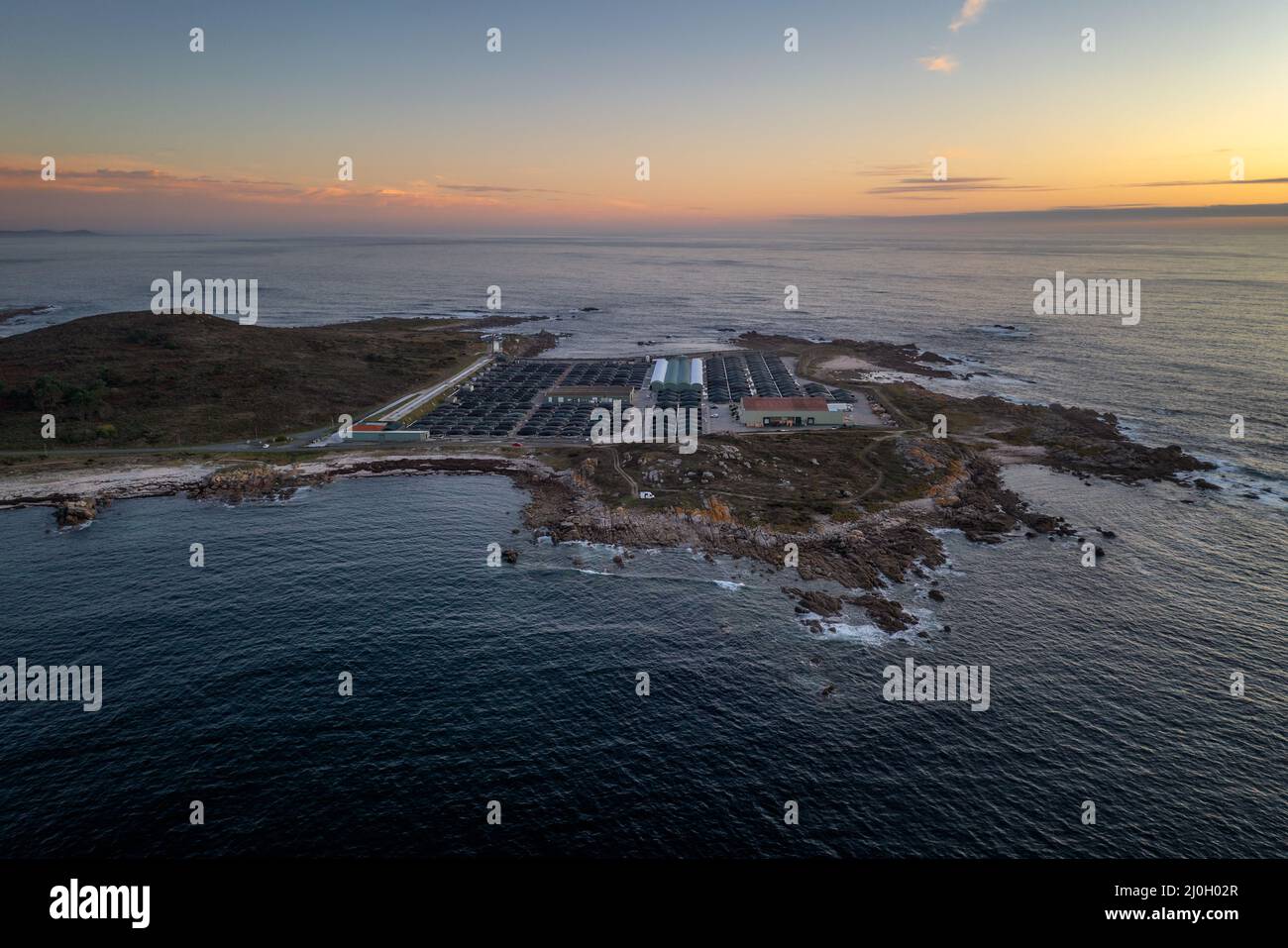 Erstaunliche Drohne Luftlandschaftsansicht einer Seefischerei auf dem Land bei Sonnenuntergang in Galiza, Spanien Stockfoto