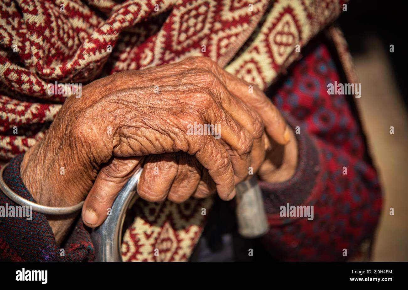 Nahaufnahme der gekreuzten faltigen Hände einer älteren Großmutter, einer nepalesischen Frau. Stockfoto