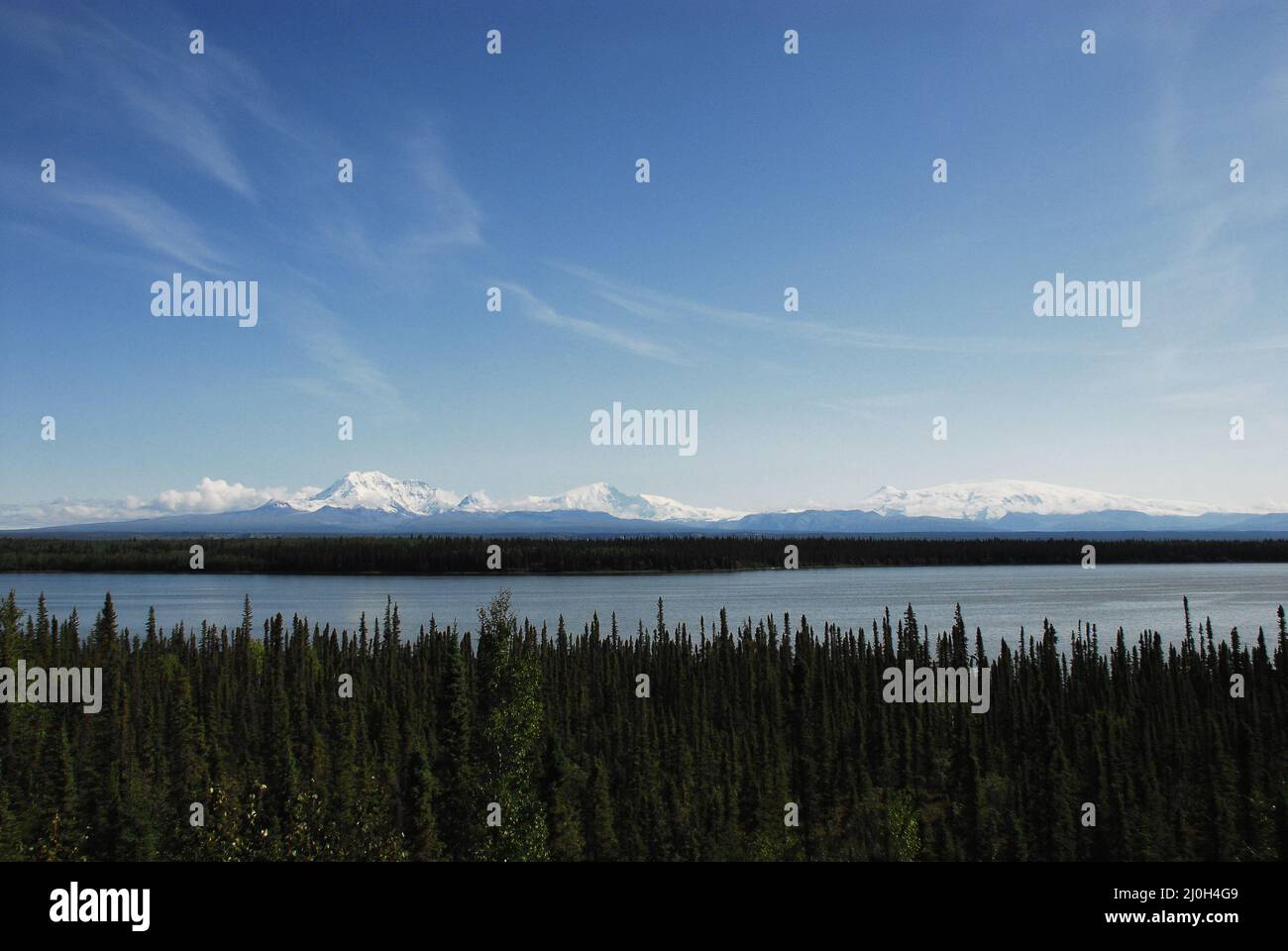 Schöne Panorama Alaskan Landschaft von fernen schneebedeckten Bergen mit einem See und Wald im Vordergrund. Stockfoto