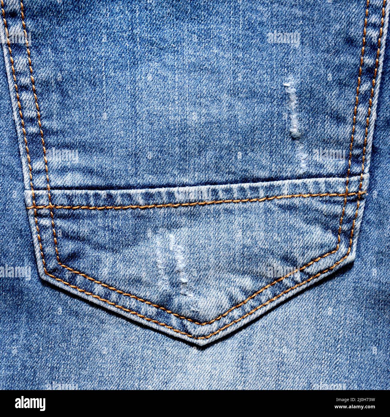 Blaue Jeans-Gesäßtasche mit Löchern und Scuffs, Naht und orangefarbenen Fadenstichen für modischen Hintergrund, Nahaufnahme. Poster-Banner-Vorlage mit Platz für die Kopie Stockfoto