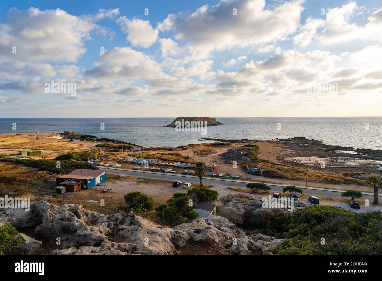 Felsige Küste von Agios Georgios Zypern. Blick auf die Insel Yeronisos. Sonnenuntergang am Hafen von Agios Georgios Pegeias in Paphos, Zypern. T Stockfoto