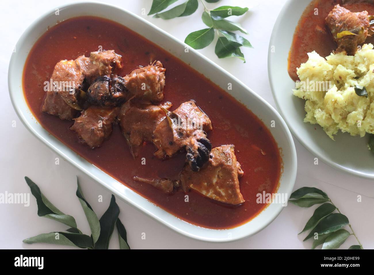 Makrelen-Currys im zentralen Kerala-Stil mit roten Chilischoten und Malabar-Tamarinde. Aufgenommen auf weißem Hintergrund. Stockfoto