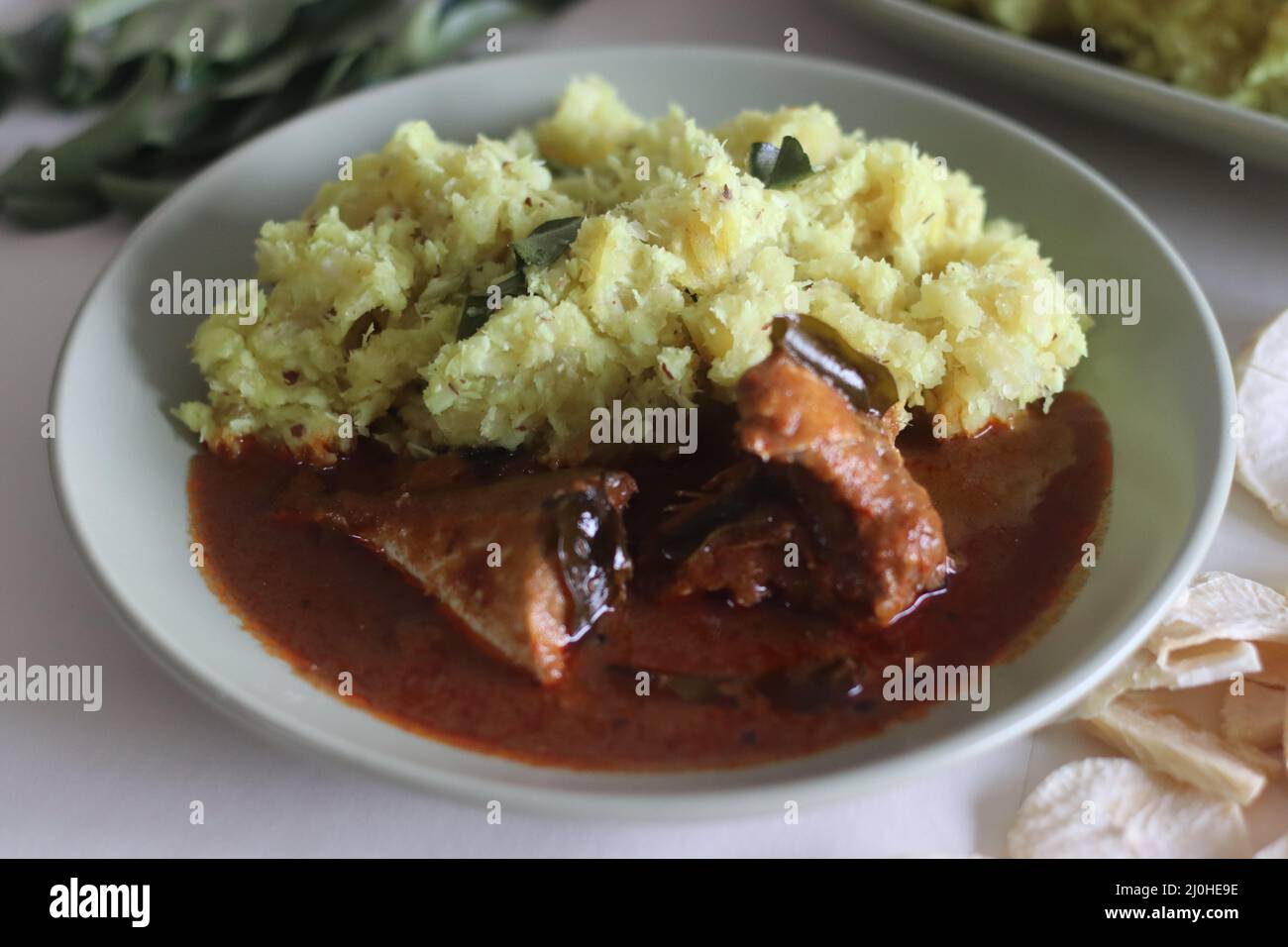 Pürierter trockener Casava oder trockener Tapioka mit geriebener Kokosnuss, Schalotten, Chilis, Kurkuma- und Curry-Blättern. Serviert mit rot-würzigem Makrelen-Makrelen-Makrele. Beliebte DIS Stockfoto