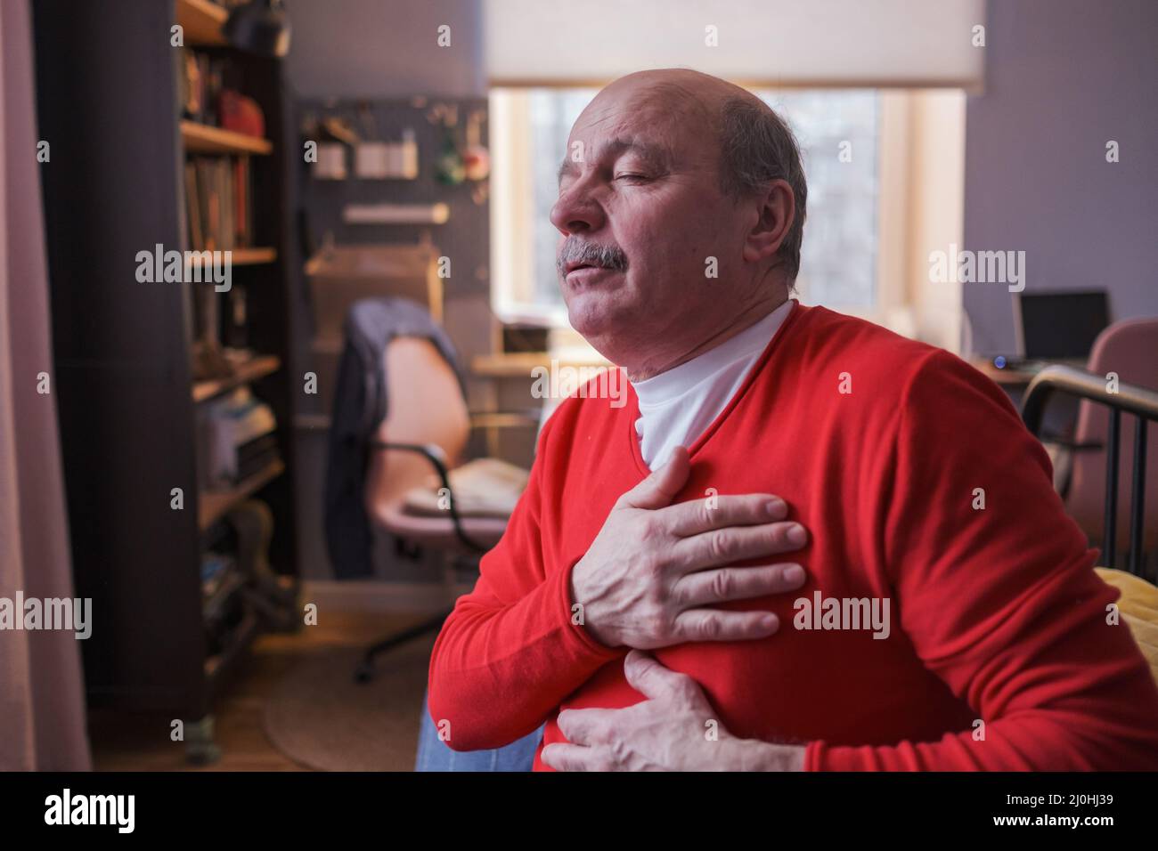 Älterer Mann, der zu Hause an schweren Schmerzen in seinem Brustherzanfall leidet. Ältere Herzkrankheit Stockfoto
