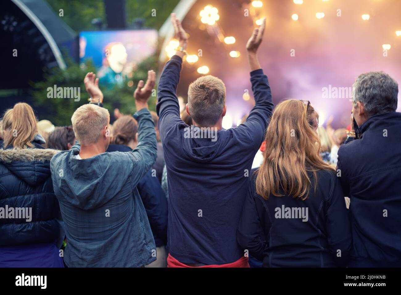 Das Publikum anbeten. Ein Publikum, das bei einer Musikveranstaltung im Freien tanzt. Stockfoto