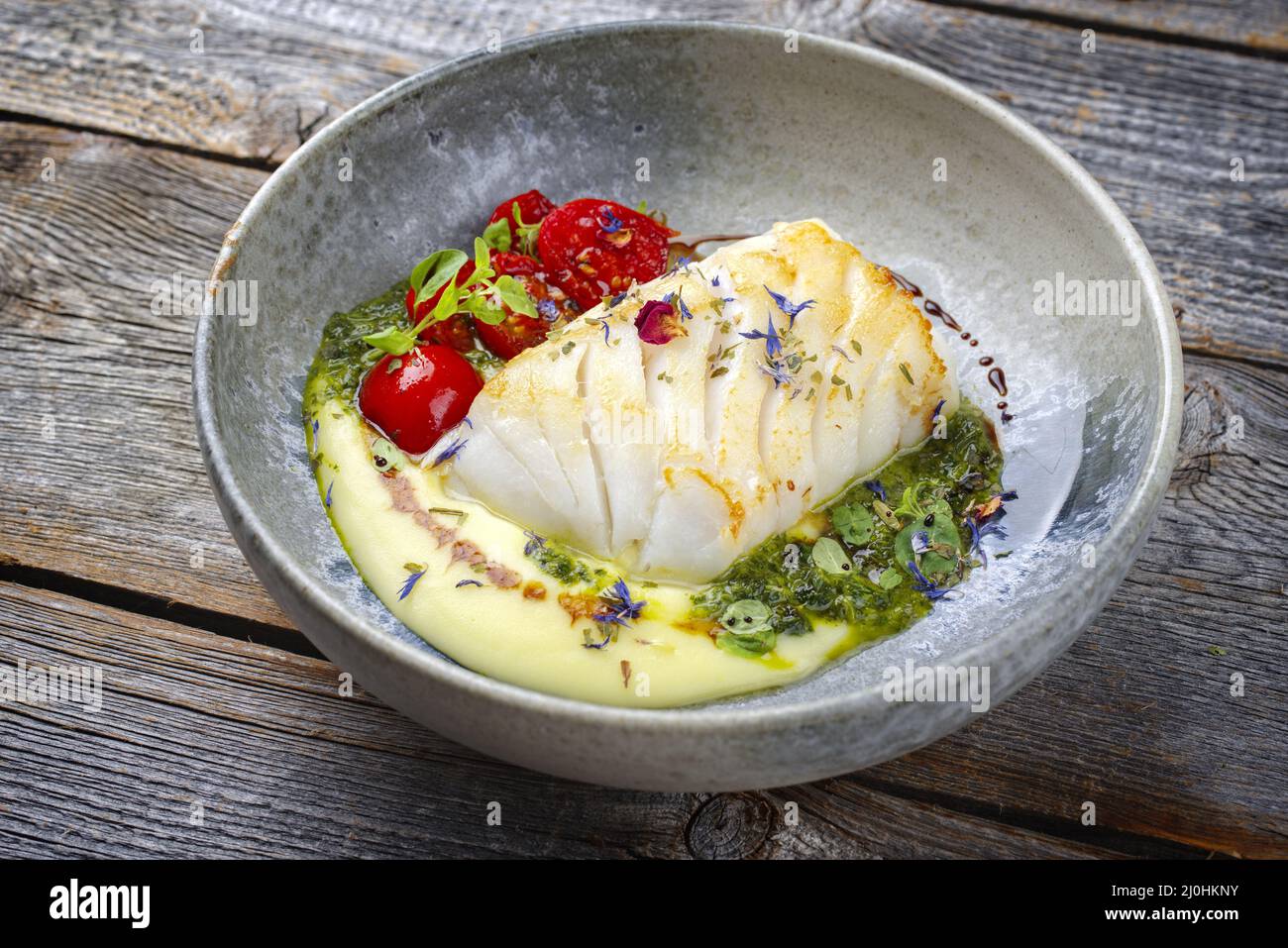 Traditionelles, gebratenes Kabeljaufischfilet im modernen Stil mit Kartoffelpüree und Koriander-Limettenreit, das als Nahaufnahme von NOR serviert wird Stockfoto