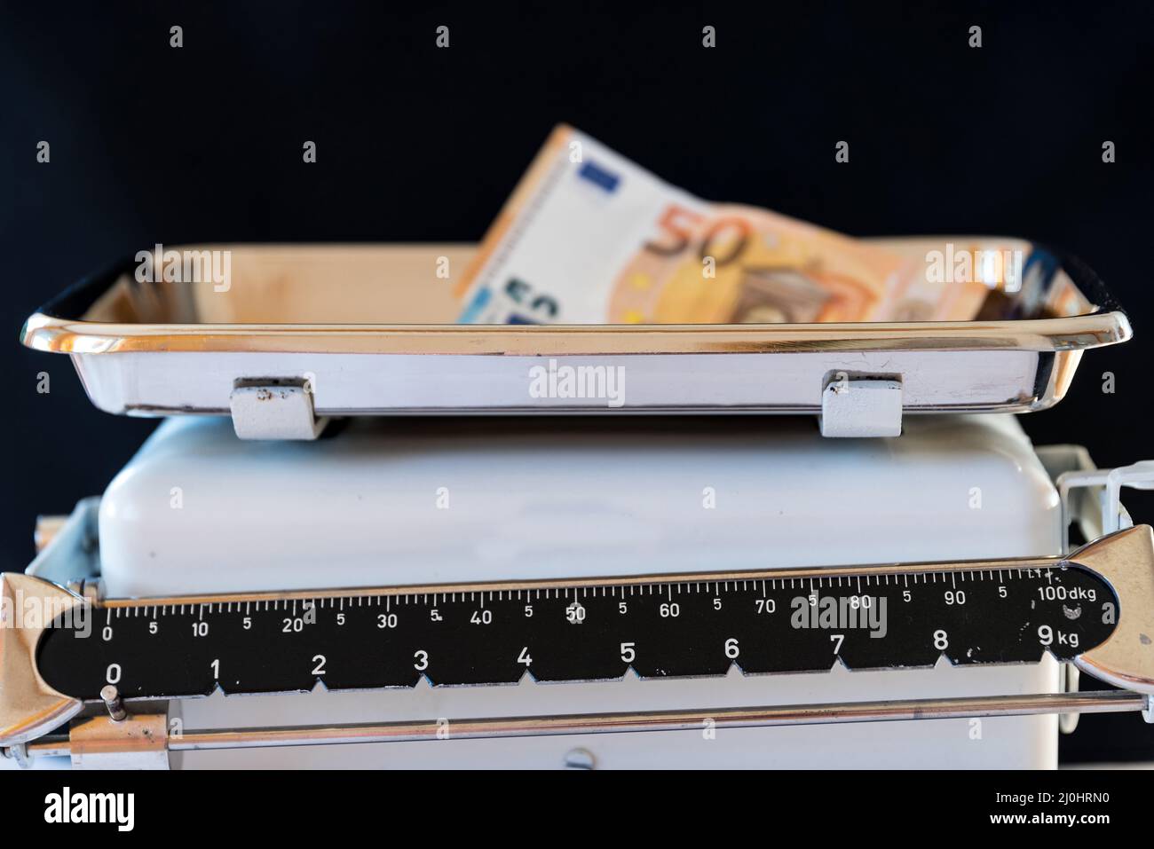 Banknote auf einer alten Küchenwaage - Werte Stockfoto