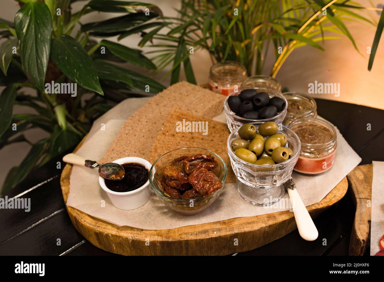 Schwarze und grüne Oliven, Saucen und getrocknetes Brot, Catering-Essen. Leckereien im rustikalen Stil. Catering-Konzept Stockfoto