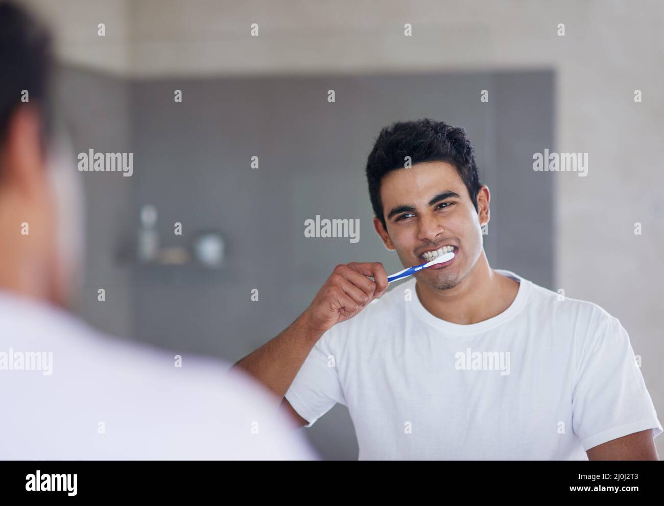 Er bürstet zweimal täglich für eine optimale Mundgesundheit. Aufnahme eines jungen Mannes, der sich zu Hause die Zähne putzt. Stockfoto