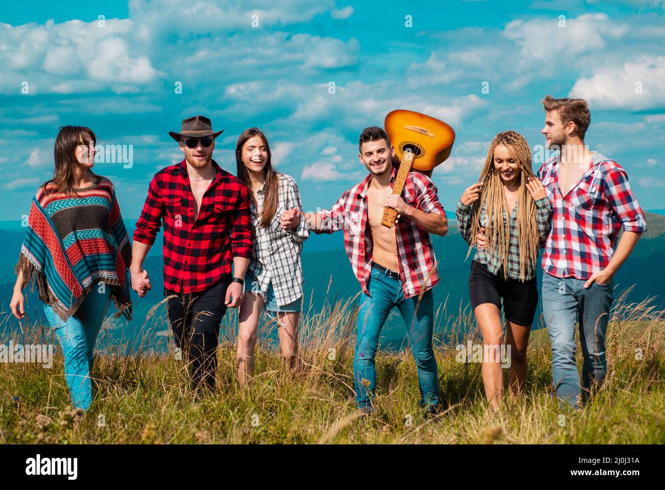 Eine Gruppe von Männern und Frauen wandern auf dem Weg während einer Wanderung durch die Berge. Abenteuer, Reisende, Touristen und Menschen Konzept. Gruppe von Wanderern Stockfoto