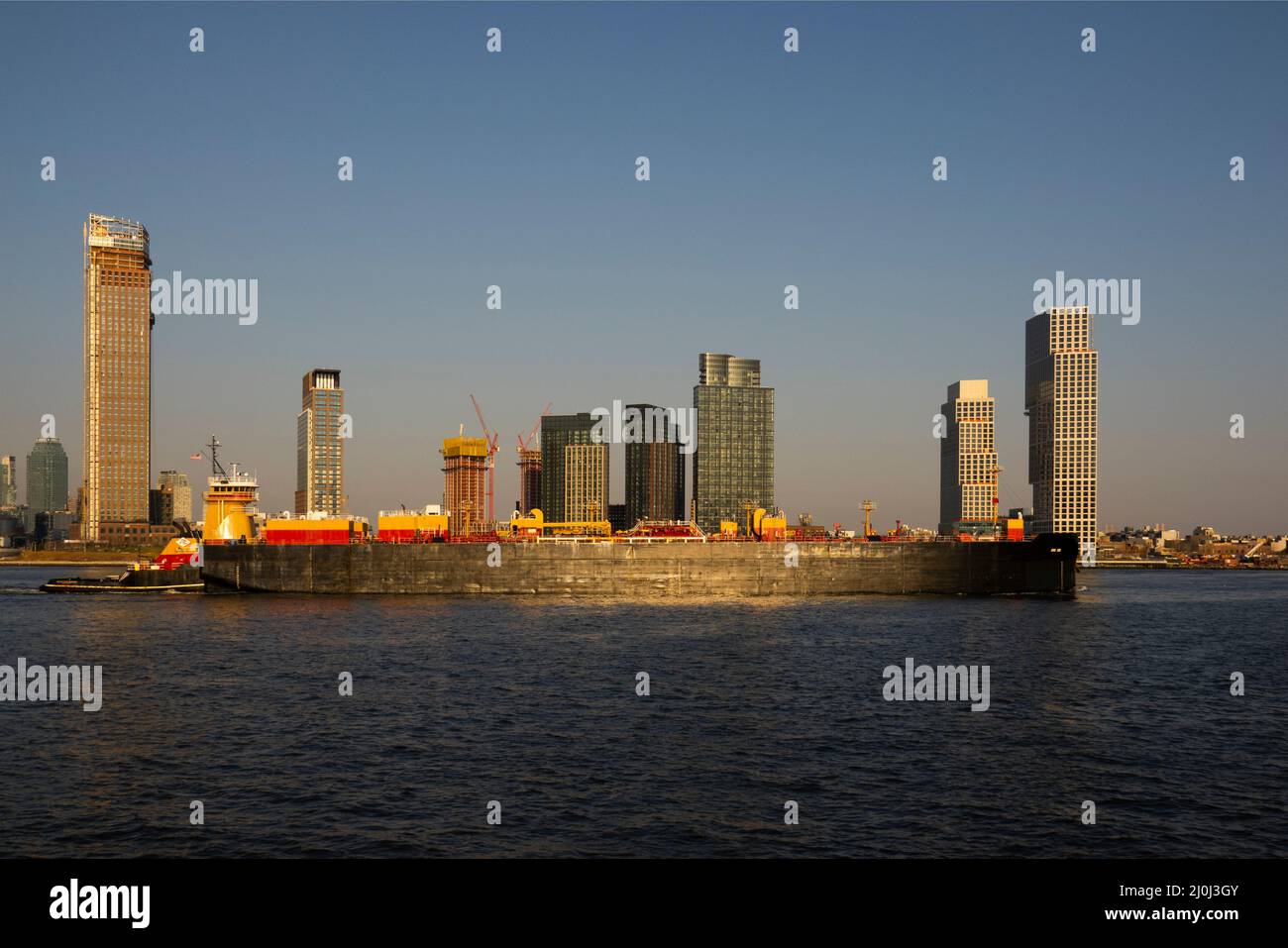 Schlepper schieben einen Tanker den East River in Long Island City Queens Waterfront in NYC hinauf Stockfoto