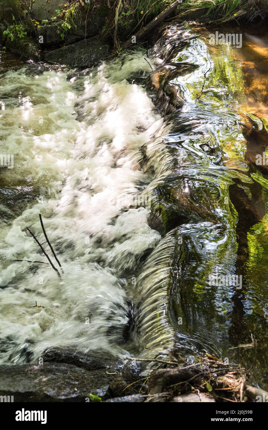 Kleiner Wasserfall eines tobenden Baches - natürliche Schönheit Stockfoto