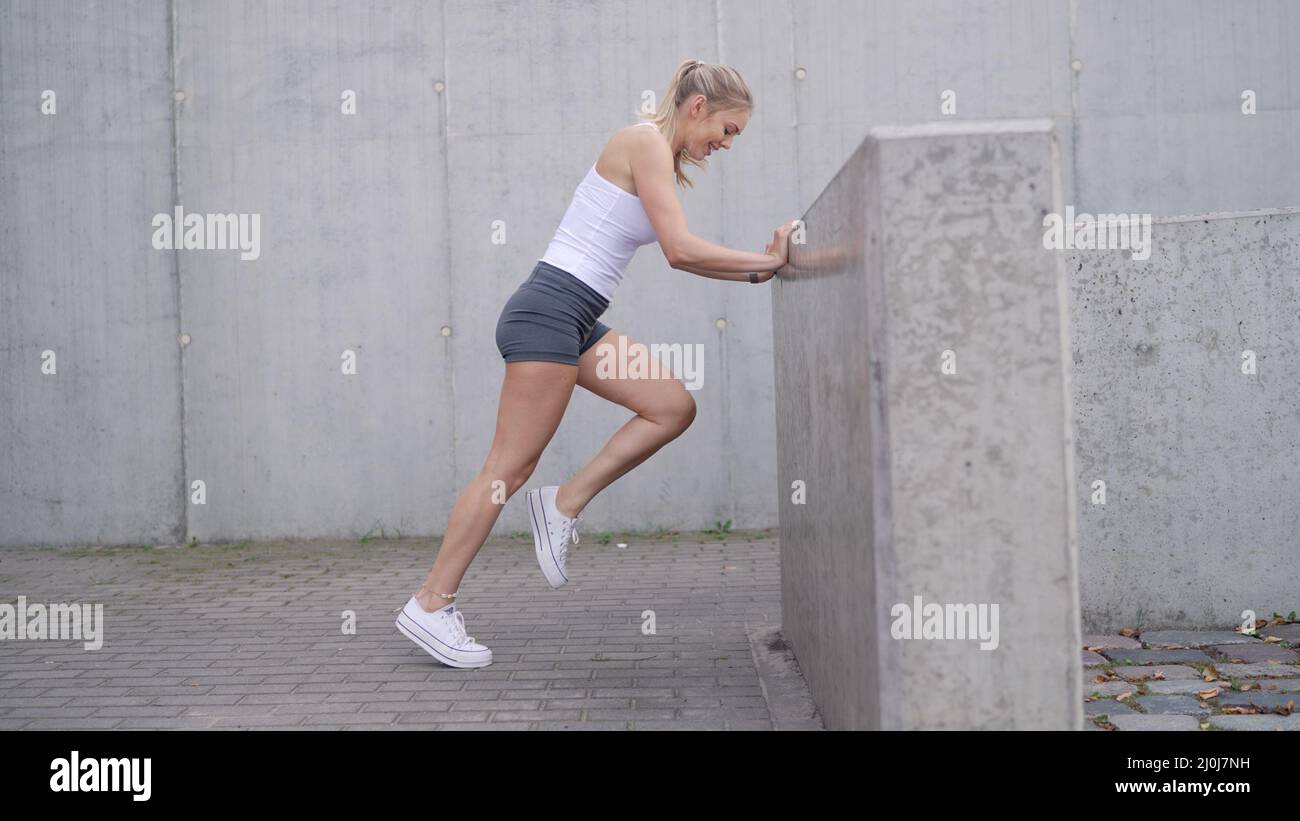 Weibliche Sportlerin, die in der Nähe der Barriere trainiert Stockfoto