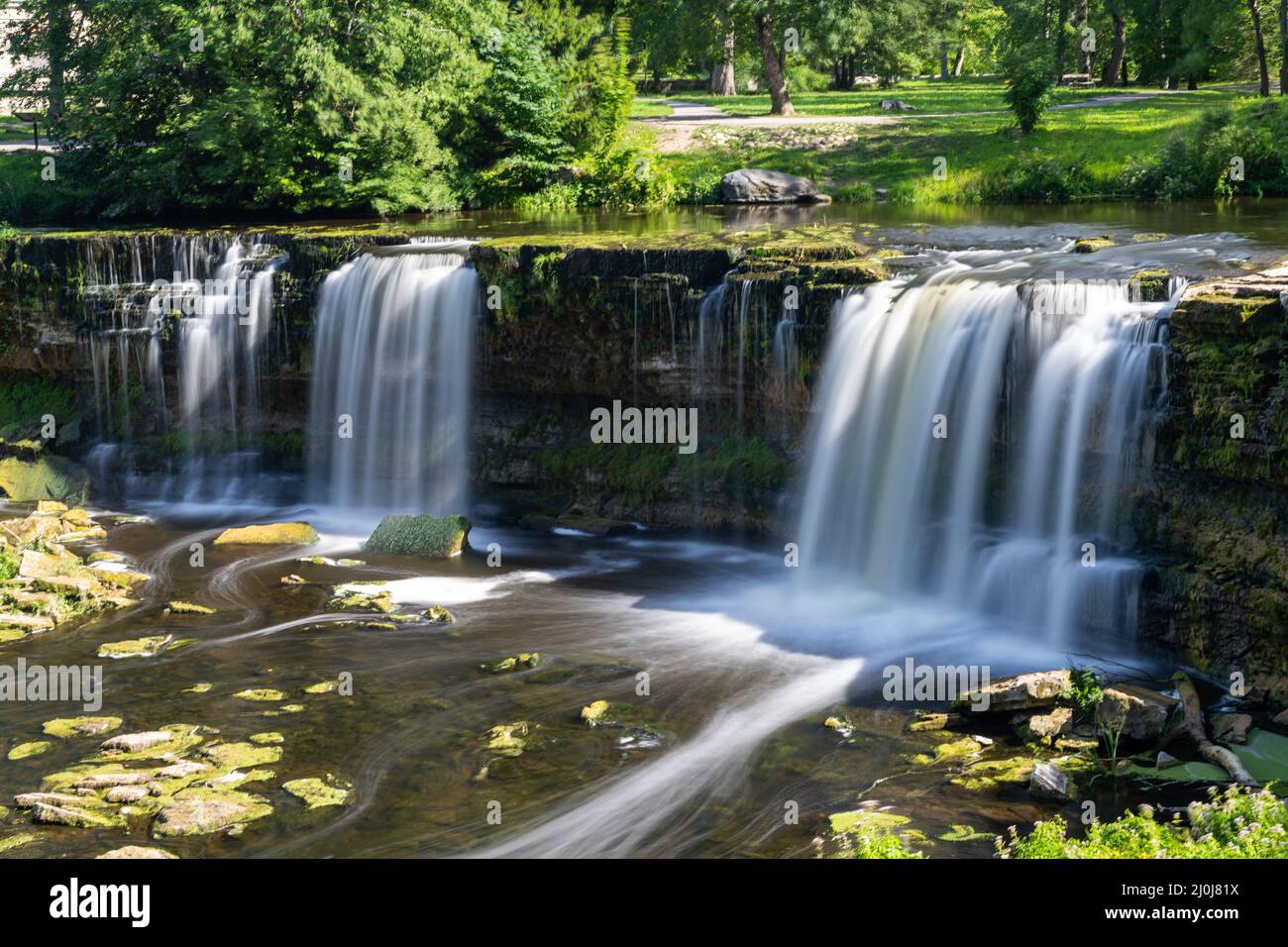 Eine idyllische Flusslandschaft im Wald mit einem Wasserfall Stockfoto