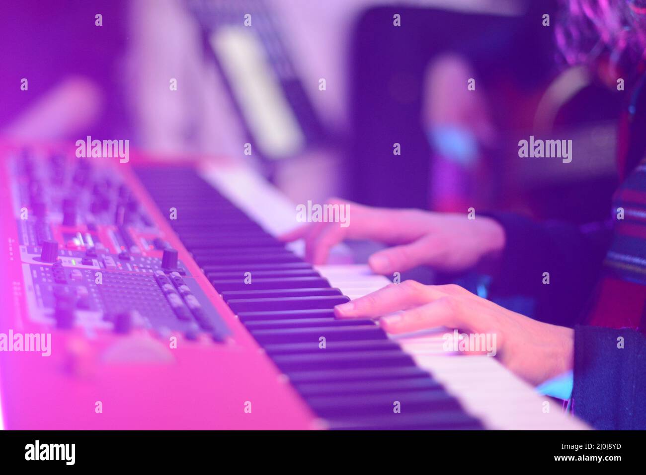 Nahaufnahme der Hände einer Musikerin, die Synthesizer bei einer Live-Show auf der Bühne spielen Stockfoto
