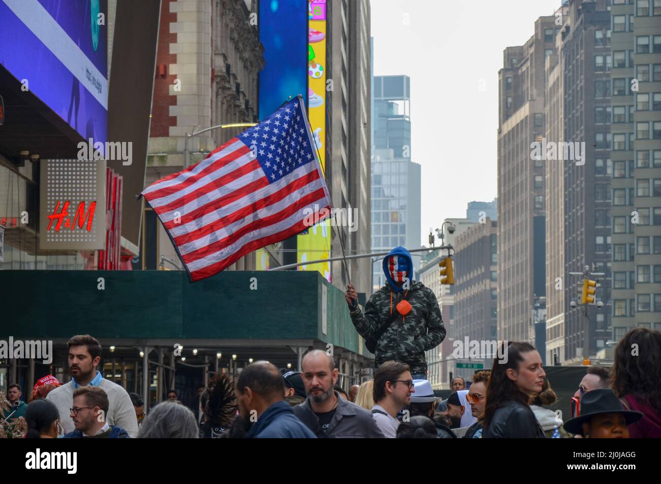 Am Times Square in New York City wird ein Demonstrator gesehen, der am 19. März 2022 eine US-Flagge hält, um Covid19 Impfstoffe und Mandate zu verurteilen. Stockfoto