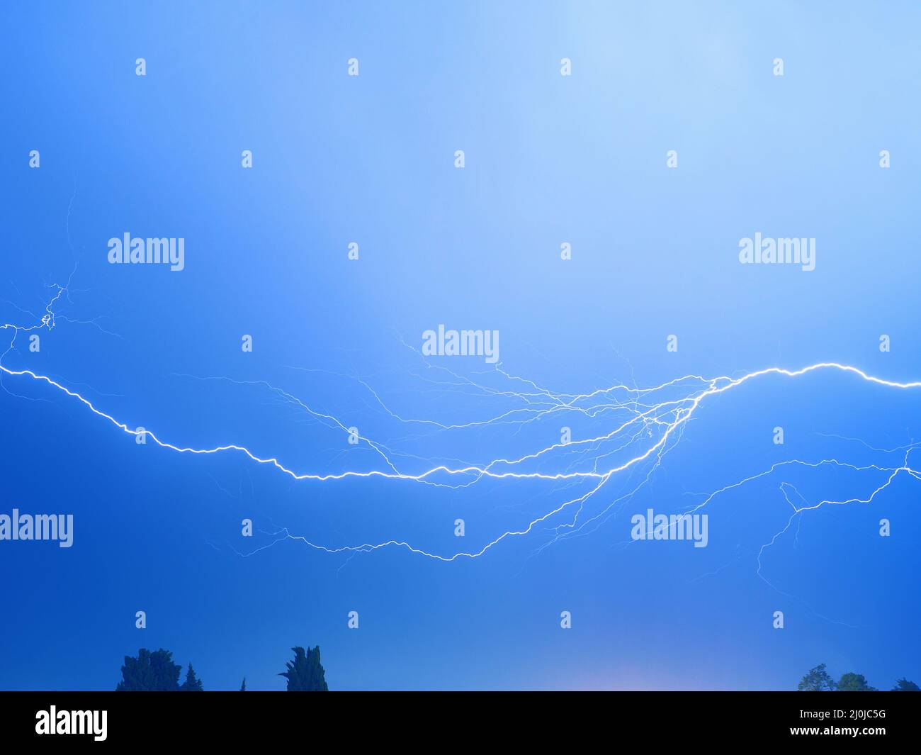 Ein verzweigter Blitz funkelt in einem strahlend blauen Himmel Stockfoto