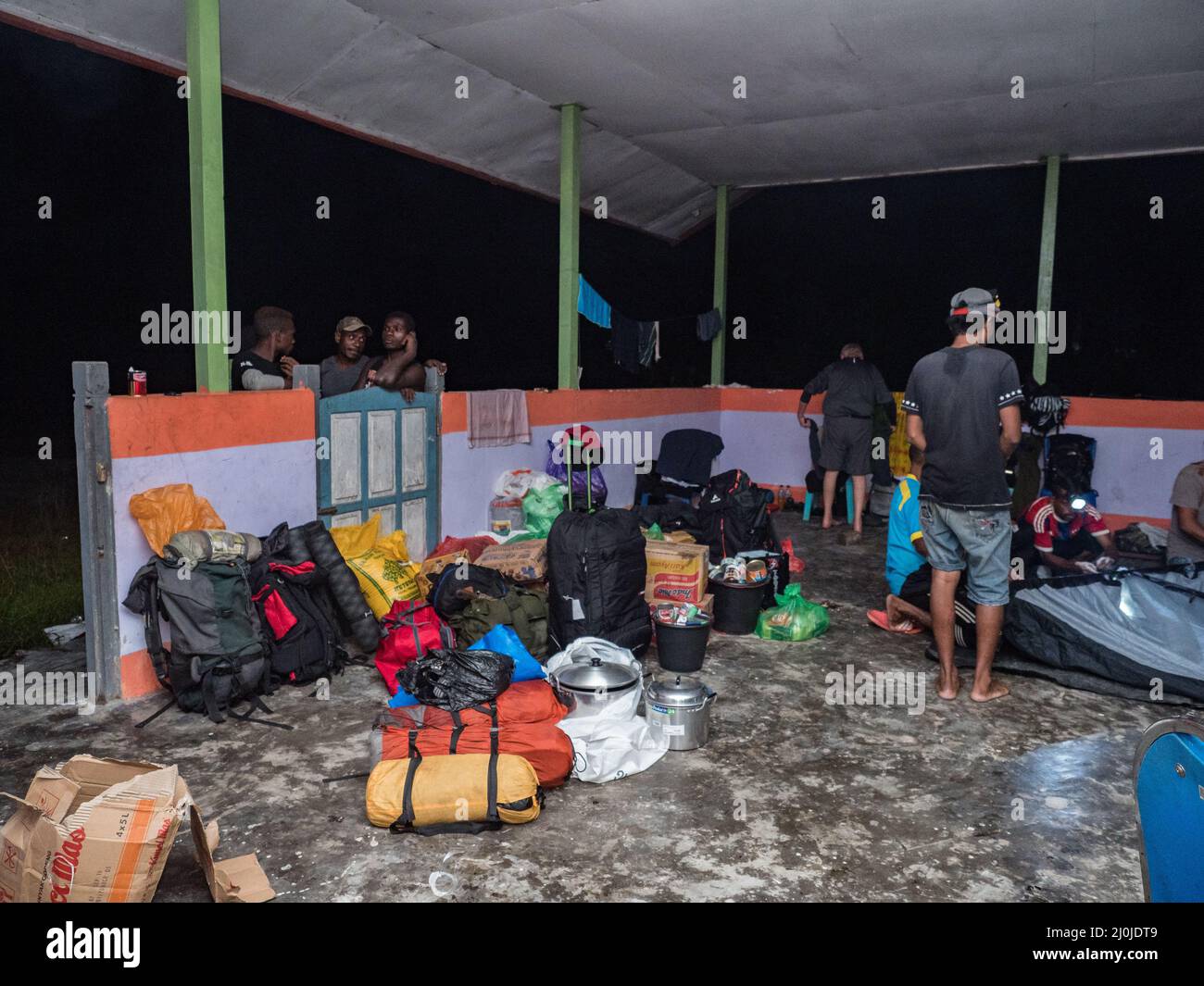 Kensi, Arguni, Indonesien - Feb, 2018: Reisegruppe bereitet während einer Expedition im Regenvorland den Zeltplatz in einem Gebäude ohne Mauern vor Stockfoto