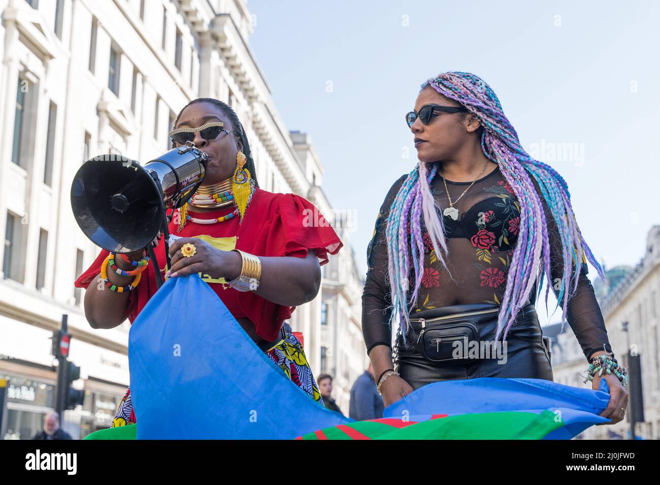 Anti-Rassismus-Protest auf den Straßen von London. Zwei weibliche schwarze Leben machen Protestierenden aus, die in ein Megaphon sprechen. London - 19.. März 2022 Stockfoto