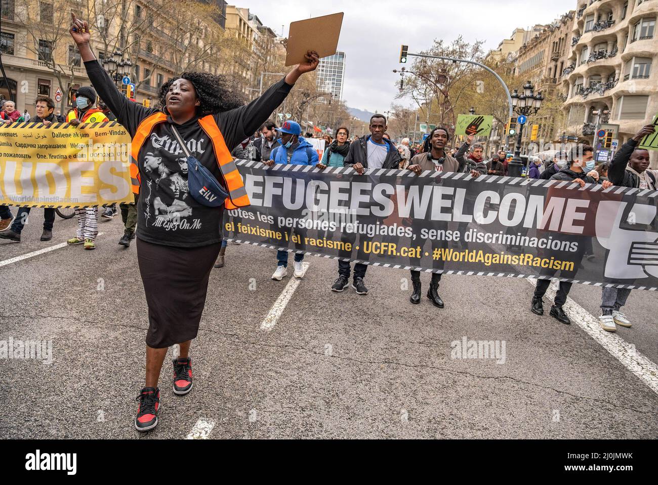 Barcelona, Spanien. 19. März 2022. Eine Frau mit erhobenen Armen und schreienden Slogans ist an der Vorderseite der Kundgebung mit dem Transparent „Alle Flüchtlinge sind willkommen“ zu sehen. Hunderte von Menschen, die von der Plattform "Einheit gegen Faschismus und Rassismus" (UCFR) aufgerufen wurden, haben in Barcelona demonstriert, um den jährlichen Internationalen Tag zur Beseitigung der Rassendiskriminierung 2022 zu feiern, der am 21. März stattfinden wird. (Foto von Paco Freire/SOPA Images/Sipa USA) Quelle: SIPA USA/Alamy Live News Stockfoto