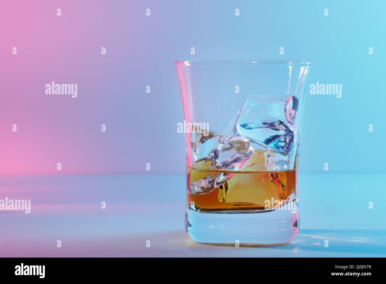 Ein Glas bernsteinfarbenem Scotch-Whiskey und Eis auf einem hellen Hintergrund Stockfoto