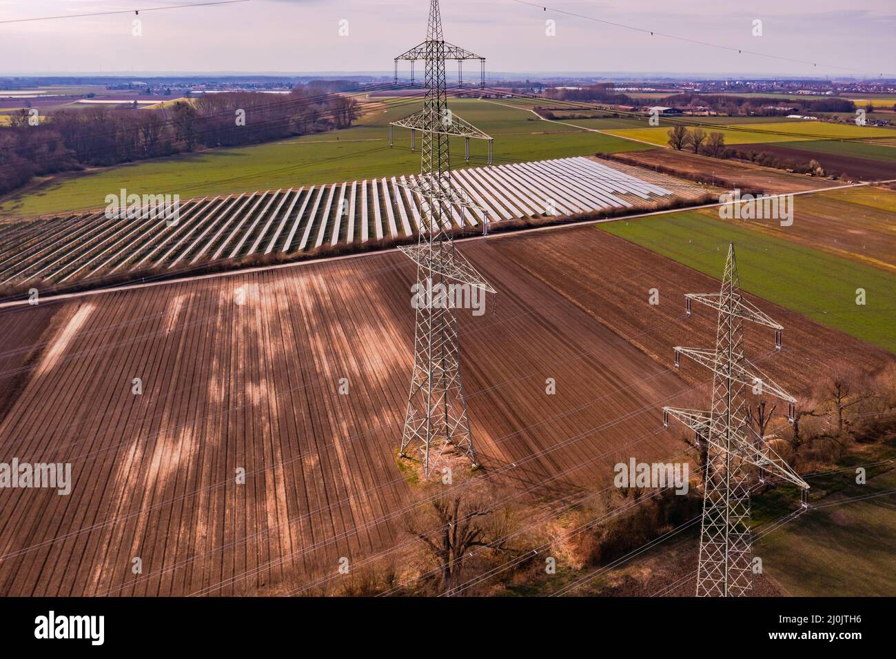 Technologie in landwirtschaftlichen Gebieten entstellt die Natur mit Strommasten und Freiflächen-Solaranlagen, Deutschland Stockfoto
