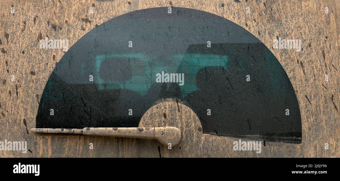 Detail einer Heckscheibe eines Fahrzeugs, das durch Regen mit Schlamm verschmutzt ist Stockfoto