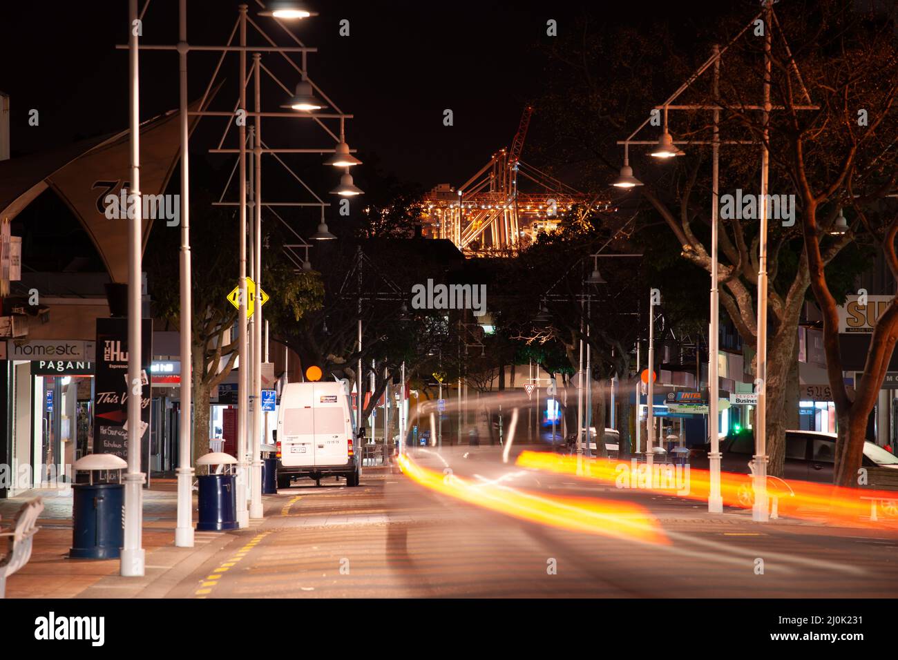 Tauranga Neuseeland - 24 2012. Juli; Straßen in der Nacht mit Licht des Hafens von Tauranga Containerkrane über dem Straßenende beleuchtet. Neuseeland. Stockfoto