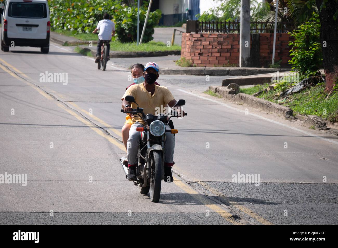 San Andrés, Kolumbien - November 17 2021: Schwarzer Mann und Frau mit Gesichtsmasken auf einem Motorrad mitten auf der Straße Stockfoto