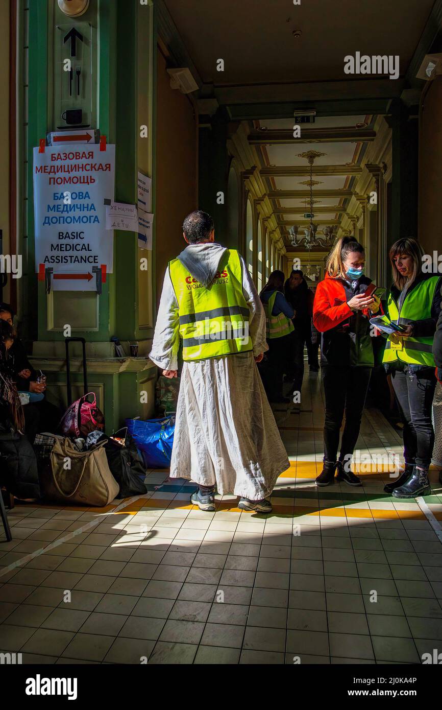 Przemysl, Ukraine. 18. März 2022. Ein religiöser Freiwilliger hilft Menschen an einem Bahnhof. Ukrainische Flüchtlinge, die vor dem Krieg in ihrer Heimat fliehen, kommen im Zug nach Polen. (Foto von Ty O'Neil/SOPA Images/Sipa USA) Quelle: SIPA USA/Alamy Live News Stockfoto