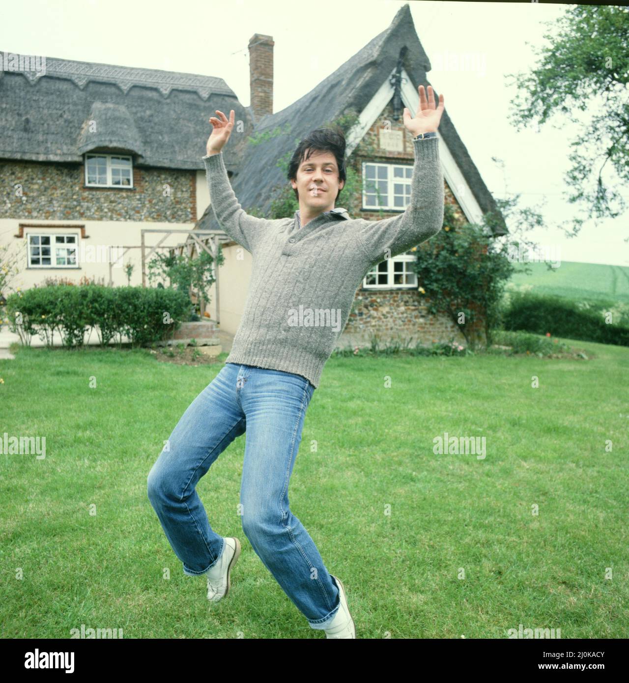 Shakin' Stevens, richtiger Name Michael Barratt (geboren am 4. März 1948 in Ely, Cardiff, in Wales), zu Hause fotografiert und einen seiner Bewegungen für die Kamera gemacht. Shakin' Stevens ist ein mit Platin verkaufter walisischer Rock and Roll-Sänger und Songwriter, der der meistverkaufte Singles-Künstler der 1980s in Großbritannien war. Im Jahr 1981 erzielte Shakin' Stevens mit „This Ole House“ seine erste britische Chart-Nummer 1 und folgte mit 10 weiteren Songs, die die Top 5 erreichten, darunter drei Nummer 1-Hits mit „Green Door“, „Oh Julie“ und „Merry Christmas Everyone“ Picture, aufgenommen um den 1.. Juli 1981 Stockfoto