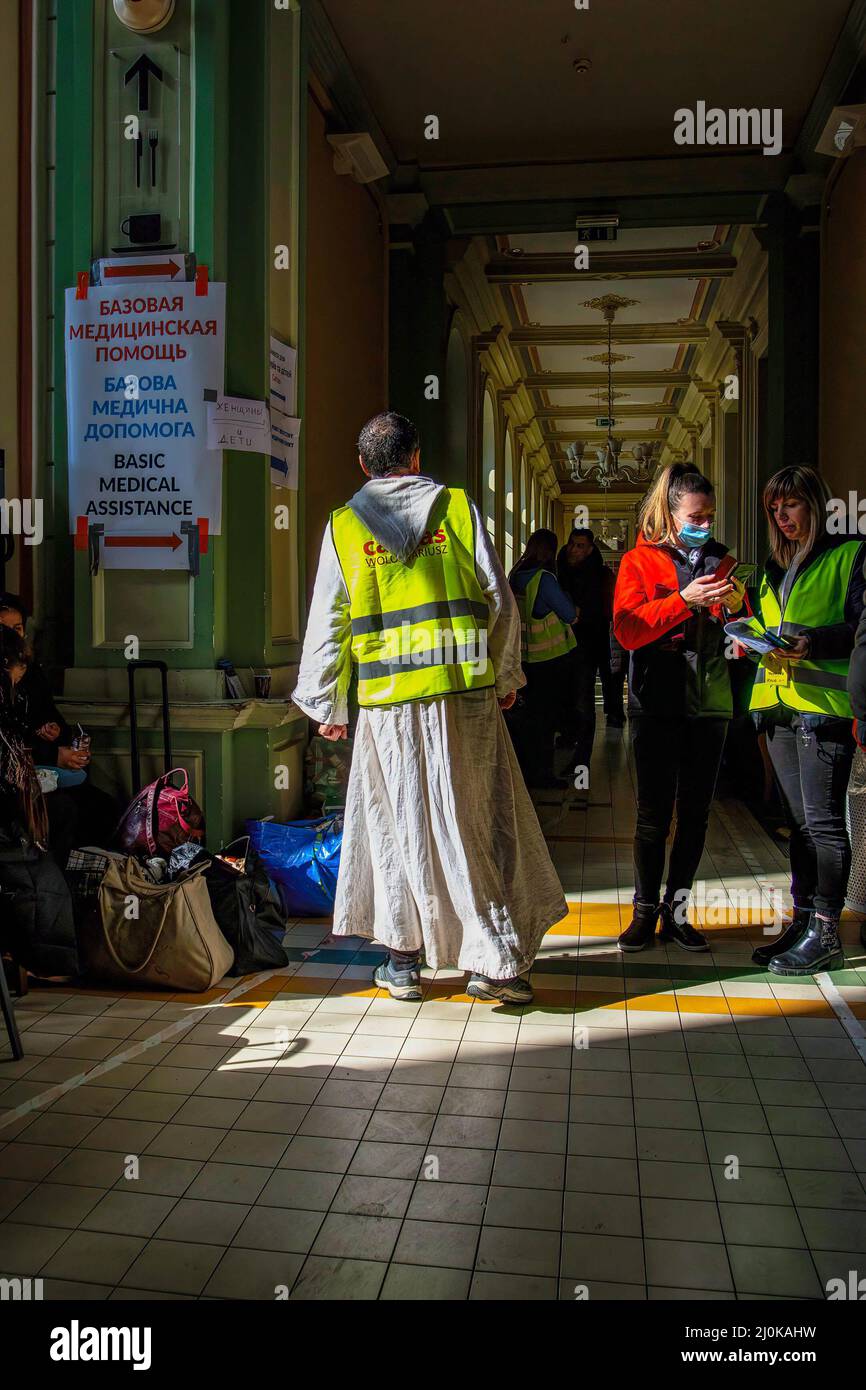 Przemysl, Ukraine. 18. März 2022. Ein religiöser Freiwilliger hilft Menschen an einem Bahnhof. Ukrainische Flüchtlinge, die vor dem Krieg in ihrer Heimat fliehen, kommen im Zug nach Polen. (Bild: © Ty O'Neil/SOPA Images via ZUMA Press Wire) Stockfoto