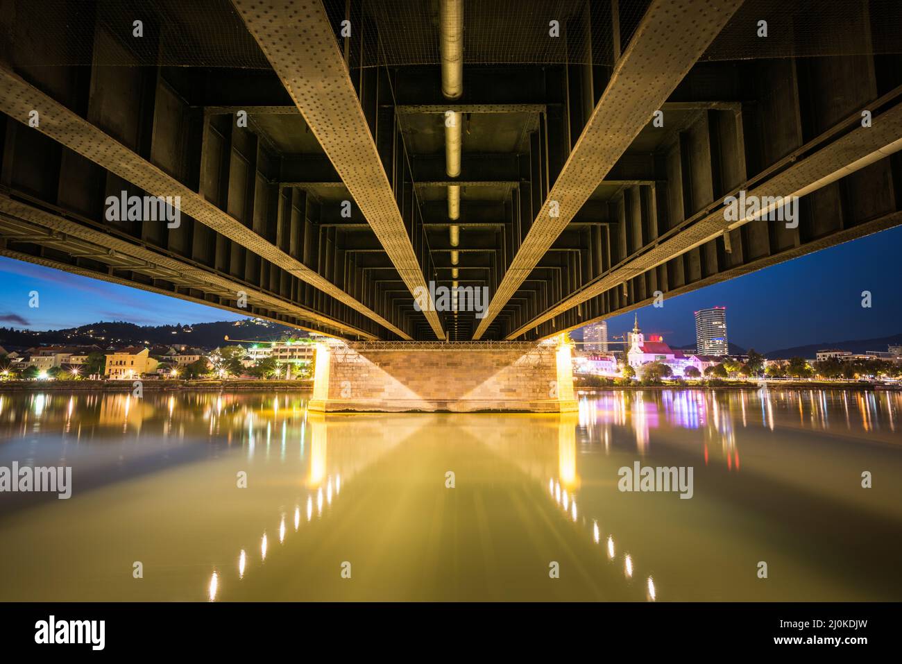 Linz Österreich Nibelungen Brückenstahlkonstruktion darunter mit Donau-Stadtbeleuchtung von Urfahr Stockfoto