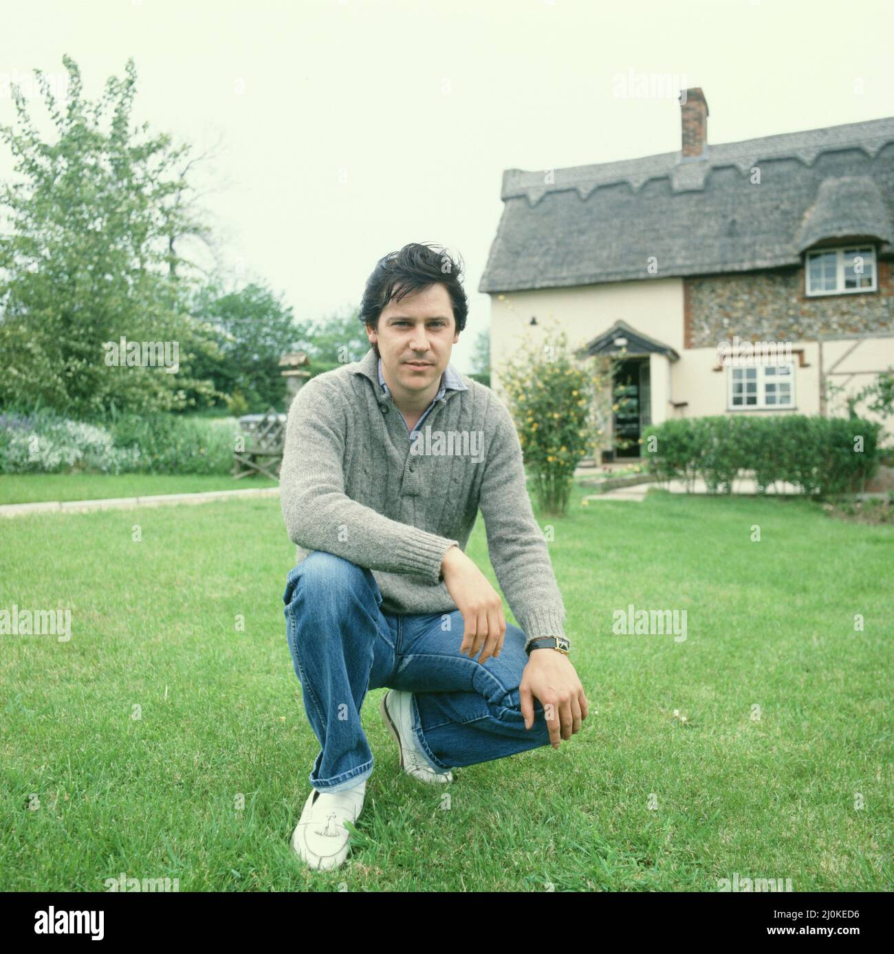 Shakin' Stevens, richtiger Name Michael Barratt (geboren am 4. März 1948 in Ely, Cardiff, in Wales), zu Hause in seinem Garten abgebildet. Sehen Sie sich ein anderes Bild in diesem Set an, in dem er eine seiner Bewegungen für die Kamera macht. Shakin' Stevens ist ein mit Platin verkaufter walisischer Rock and Roll-Sänger und Songwriter, der der meistverkaufte Singles-Künstler der 1980s in Großbritannien war. Im Jahr 1981 erzielte Shakin' Stevens mit „This Ole House“ seine erste britische Chart-Nummer 1 und folgte mit 10 weiteren Songs, die unter die Top 5 kamen, darunter drei Nummer 1-Hits mit „Green Door“, „Oh Julie“ und „Merry Christmas Everyone“ Picture Take Stockfoto