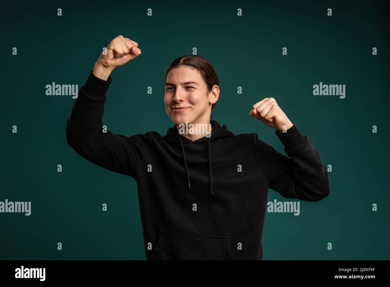 Gewinnerausdruck eines jungen Mannes. Beschnittenes Studioporträt der männlichen Stimmung Stockfoto