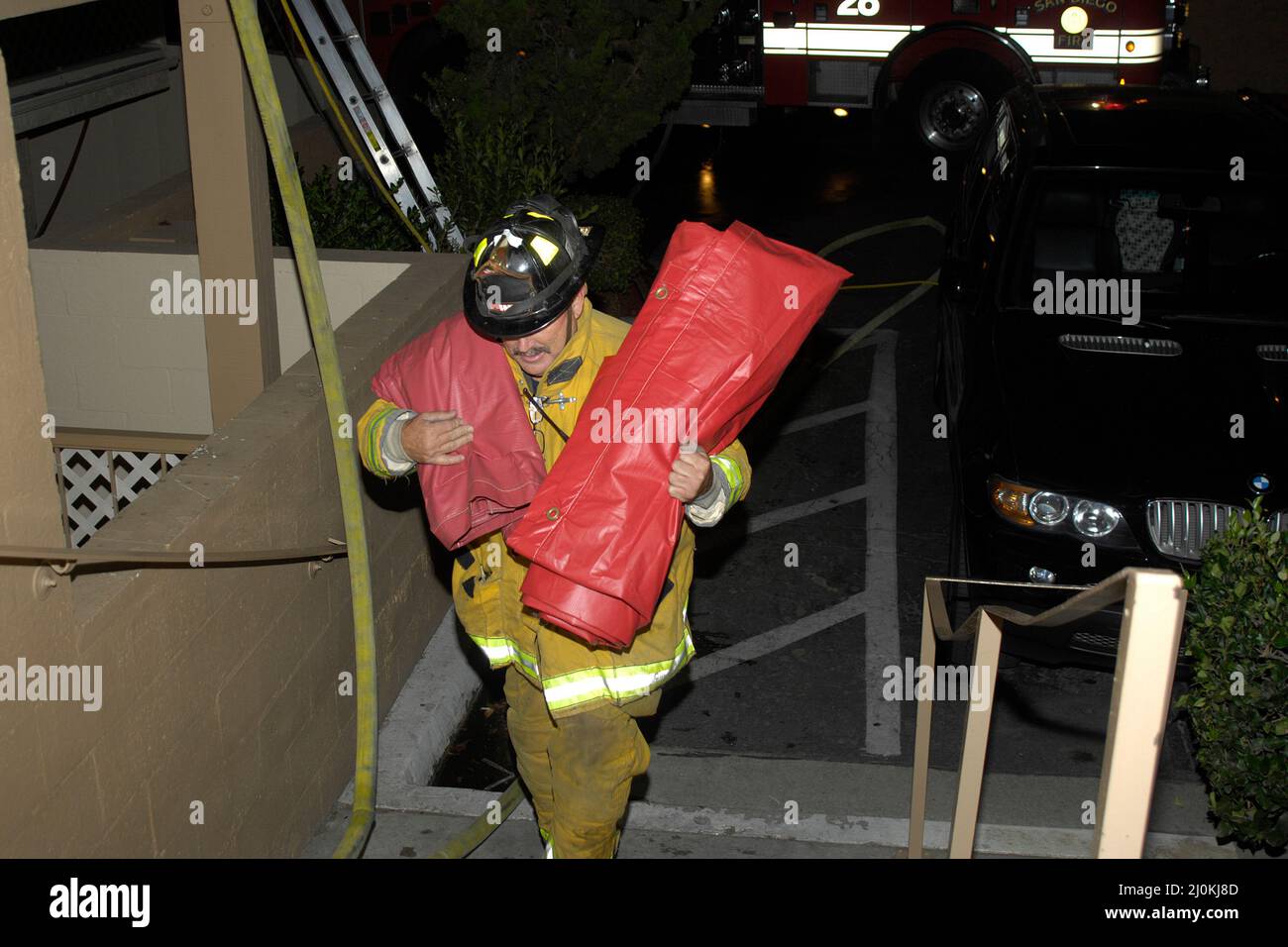 Der Feuerwehrmann aus San Diego trägt bei einem Gebäudebrand Bergungsabdeckungen Stockfoto