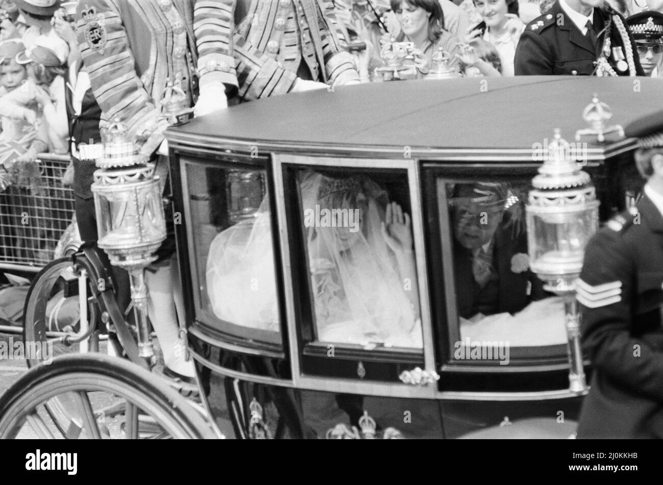 Lady Diana Spencer und ihr Vater Earl Spencer in der königlichen Kutsche, die das Clarence House verlässt, um zur St. Paul's Cathedral zu gehen, um Diana mit Prinz Charles, dem Prinz von Wales, zu heiraten. Diana wird gesehen, wie sie der Menge zuwinkt. Sie trägt ein von David und Elizabeth Emanuel entworfenes Elfenbein-Taft und ein antikes Spitzenkleid mit einem Zug von 25ft (7,62m) Bild aufgenommen am 29.. Juli 1981 Stockfoto