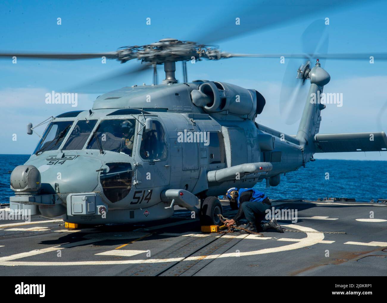 220301-N-EH998-1026 ATLANTISCHER OZEAN (MÄRZ 1,2022) David Wright, die Mate 3.-Klasse von Boatswain, sichert sich einen MH-60 Sea Hawk-Hubschrauber, der dem Hubschrauber Maritime Strike Squadron (HSM) 26 zugewiesen wurde, an Bord des Lenkraketen-Zerstörers USS Farragut (DDG 99), während er für Surface Warfare Advanced Tactical Training (SWATT) unterwegs ist. Farragut ist Teil von Destroyer Squadron (DESRON) 26, das die Carrier Strike Group (CSG) 10 unterstützt. SWATT wird vom Naval Surface and Mine Warfighting Development Center (SMWDC) geleitet und soll die Kampffähigkeit, Letalität und Interoperabilität der teilnehmenden Einheiten verbessern. Stockfoto