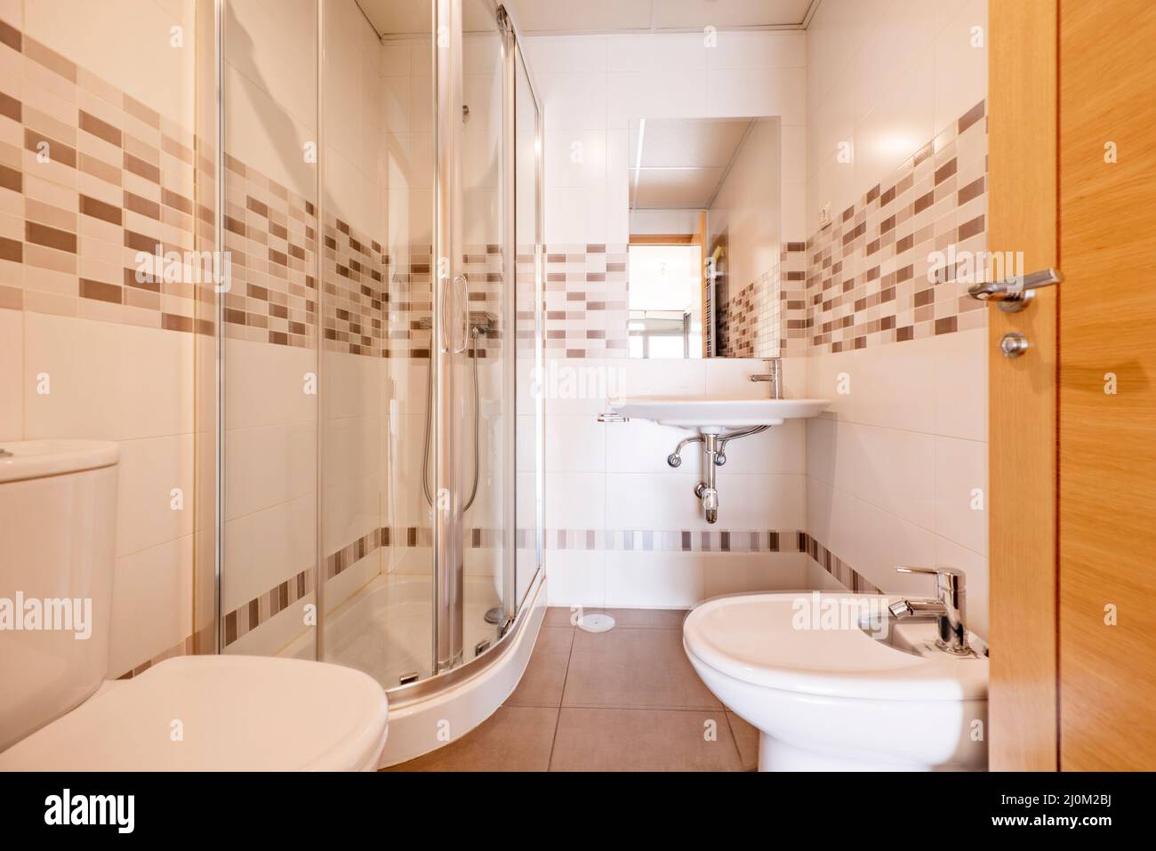 Badezimmer mit Waschbecken, Bidet, Viertelkreisduschkabine, eingelassenem  Spiegel und breiter Bordüre Stockfotografie - Alamy