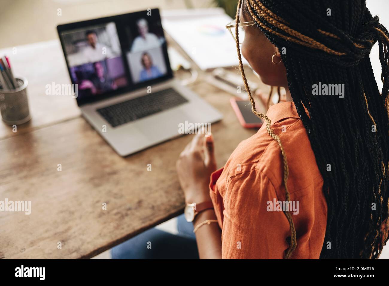 Grafikdesignerin, die an einem virtuellen Meeting mit ihren Kunden teilnimmt. Kreative Freiberuflerin, die einen Laptop für einen Videoanruf verwendet. Junge Frau, die an einem n arbeitet Stockfoto