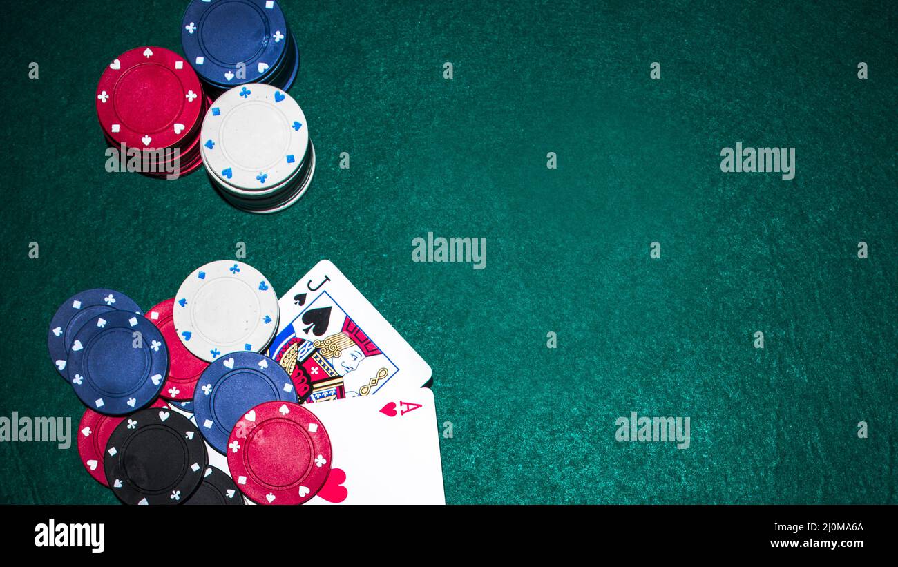 Jack Spade Herz Ass Karte mit Casino Chips grünen Pokertisch Stockfoto