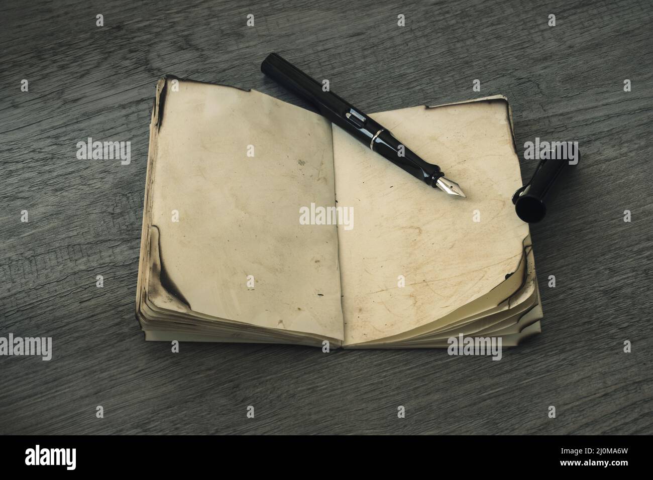 Tintenstift hat altes Notebook geöffnet Stockfoto